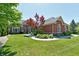 Charming brick home featuring lush landscaping, healthy green lawn and beautiful curb appeal at 7413 Misty Woods Ln, Indianapolis, IN 46237