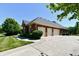 Three-car garage with brick exterior and ample parking space, complemented by a well-manicured lawn at 7413 Misty Woods Ln, Indianapolis, IN 46237