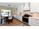 Well-lit kitchen with white cabinets, an island with seating, and stainless steel appliances at 7413 Misty Woods Ln, Indianapolis, IN 46237