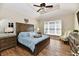 This primary bedroom features a tray ceiling, ceiling fan and lots of natural light at 7413 Misty Woods Ln, Indianapolis, IN 46237
