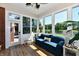 Light-filled sunroom showcases views of the lake, comfortable blue sofa, and an inviting atmosphere at 7413 Misty Woods Ln, Indianapolis, IN 46237