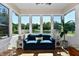 Bright sunroom featuring large windows with beautiful lake views, comfortable seating, and natural light at 7413 Misty Woods Ln, Indianapolis, IN 46237