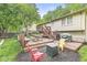 Spacious backyard deck with a picnic table, firepit, BBQ and colorful lawn chairs surrounded by lush greenery at 7616 E Concord Ln, Fishers, IN 46038