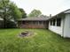 Spacious backyard with well-maintained lawn, trees, and partial brick exterior at 7721 Hollybrook Ln, Indianapolis, IN 46227