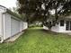 Green backyard view with a detached garage and white siding on the main house, showcasing outdoor space at 7721 Hollybrook Ln, Indianapolis, IN 46227