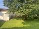 Backyard view of green grass, privacy fence, and detached garage at 7721 Hollybrook Ln, Indianapolis, IN 46227