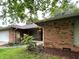Classic brick ranch home with manicured front lawn and a covered porch at 7721 Hollybrook Ln, Indianapolis, IN 46227