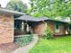 Inviting brick home entrance with covered porch and green lawn at 7721 Hollybrook Ln, Indianapolis, IN 46227