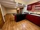 View of open concept kitchen with cherry cabinets, island cooktop, and hardwood floors at 7721 Hollybrook Ln, Indianapolis, IN 46227
