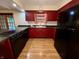 View of kitchen with cherry cabinets, island cooktop, and hardwood floors at 7721 Hollybrook Ln, Indianapolis, IN 46227