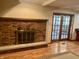 Living room with wood floors, brick fireplace, and access to outdoor deck at 7721 Hollybrook Ln, Indianapolis, IN 46227