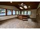 The sunroom features a hot tub, brick floors, wood paneling, and several windows at 7721 Hollybrook Ln, Indianapolis, IN 46227