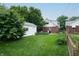 A large backyard with lush lawn, storage shed, and privacy fence at 828 N Butler Ave, Indianapolis, IN 46219