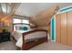 Charming bedroom with wood paneling, sloped ceilings, and warm lighting at 828 N Butler Ave, Indianapolis, IN 46219