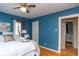 Comfortable bedroom with blue accent wall, ceiling fan, and view into the Bedroom at 828 N Butler Ave, Indianapolis, IN 46219