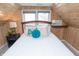 Charming bedroom featuring wood paneling, a comfortable bed, and natural light from the window at 828 N Butler Ave, Indianapolis, IN 46219
