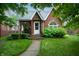Charming brick house with well-manicured lawn and a welcoming front porch at 828 N Butler Ave, Indianapolis, IN 46219
