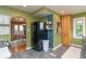 Kitchen with view of eat in bar, refrigerator, floating shelves, green paint and wood cabinets at 828 N Butler Ave, Indianapolis, IN 46219