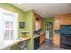 Kitchen with breakfast bar, sink, wood cabinets and black oven at 828 N Butler Ave, Indianapolis, IN 46219