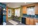 Eat-in kitchen with bar seating, green paint, wood cabinets, and geometric tile backsplash at 828 N Butler Ave, Indianapolis, IN 46219