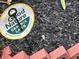 Close-up of mulch on the lawn with a sign for Good Nature Organic Lawn at 828 N Butler Ave, Indianapolis, IN 46219