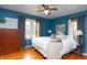 Cozy bedroom featuring a large window, decorative lamps, and a comfortable king bed at 828 N Butler Ave, Indianapolis, IN 46219