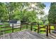 View of the backyard with a wooden deck and a shed, surrounded by lush trees and greenery, offering privacy at 8920 Caminito Rd, Indianapolis, IN 46234