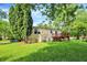 Spacious backyard featuring mature trees, lush green grass, and a charming home at 8920 Caminito Rd, Indianapolis, IN 46234