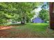 A spacious backyard, surrounded by mature trees, with a well-manicured lawn at 8920 Caminito Rd, Indianapolis, IN 46234