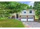 Split-level home featuring a two-car garage, siding, and landscaped front yard at 8920 Caminito Rd, Indianapolis, IN 46234