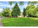 Expansive front yard with lush green grass and mature trees, enhancing curb appeal and providing a welcoming entrance at 8920 Caminito Rd, Indianapolis, IN 46234