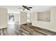Bright living room featuring wood flooring, a ceiling fan, and open access to the kitchen and dining areas at 8920 Caminito Rd, Indianapolis, IN 46234