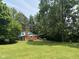 Spacious backyard with lush lawn and trees, with a blue and brick home, for relaxation and outdoor activities at 9011 Camby Rd, Camby, IN 46113