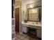 Classic bathroom with a vanity, decorative mirror, and patterned wallpaper, offering vintage charm at 9011 Camby Rd, Camby, IN 46113