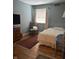 Cozy bedroom featuring hardwood floors, an area rug, natural light, and comfortable furnishings at 9011 Camby Rd, Camby, IN 46113