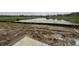 Muddy backyard featuring a retaining wall and pond views, ready for landscape design at 9137 Steinbeck Ln, Indianapolis, IN 46239