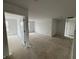 Unfinished room featuring white walls and trim, a door leading to another room and a view of the neighborhood at 9137 Steinbeck Ln, Indianapolis, IN 46239