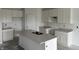 Unfinished kitchen featuring white cabinetry, grey countertops, and a kitchen island with a double sink at 9137 Steinbeck Ln, Indianapolis, IN 46239