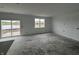 Unfinished living room featuring a sliding glass door leading to the backyard, a window, and white walls at 9137 Steinbeck Ln, Indianapolis, IN 46239