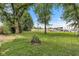 Expansive backyard with mature trees, natural wood border, and space for recreation and relaxation at 917 W Pearl St, Lebanon, IN 46052