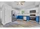 Bright kitchen with stainless steel refrigerator, white cabinets, and blue lowers is perfect for modern cooking and entertaining at 917 W Pearl St, Lebanon, IN 46052