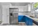 Well-equipped kitchen with stainless steel refrigerator, blue cabinets, and stylish backsplash offers a contemporary touch at 917 W Pearl St, Lebanon, IN 46052