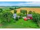 Sprawling country estate featuring a charming farmhouse, vibrant red barn, outbuildings, and surrounding farmland at 9237 N 500 W, Fountaintown, IN 46130