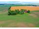 Picturesque aerial of a farmhouse and barn enveloped by green fields, highlighted by a brilliant golden field at 9237 N 500 W, Fountaintown, IN 46130