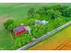Aerial view of farmhouse with red barn with a lush green lawn bordered by golden farm fields at 9237 N 500 W, Fountaintown, IN 46130