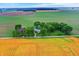 Elevated aerial showing a cozy farm with a red barn enveloped by green and golden fields on a cloudy day at 9237 N 500 W, Fountaintown, IN 46130