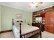 Comfortable bedroom featuring a bed, rustic-style walls, wood furniture, a ceiling fan, and natural light at 9237 N 500 W, Fountaintown, IN 46130