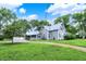 Quaint gray home featuring a detached garage, gravel driveway, and lush landscaping at 9237 N 500 W, Fountaintown, IN 46130