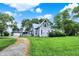 Charming gray home with detached garage, surrounded by lush greenery and a gravel driveway at 9237 N 500 W, Fountaintown, IN 46130