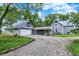 Gray home with detached garage, screened porch, and gravel driveway, nestled among mature trees and greenery at 9237 N 500 W, Fountaintown, IN 46130